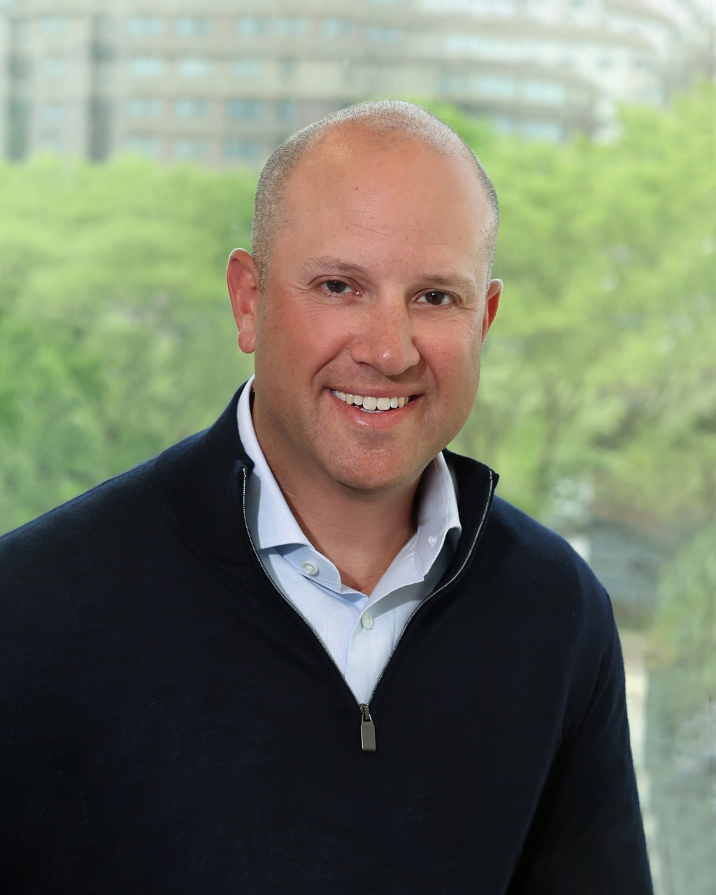 Matt Goode, a professional at Venture One, smiling in front of a green background.