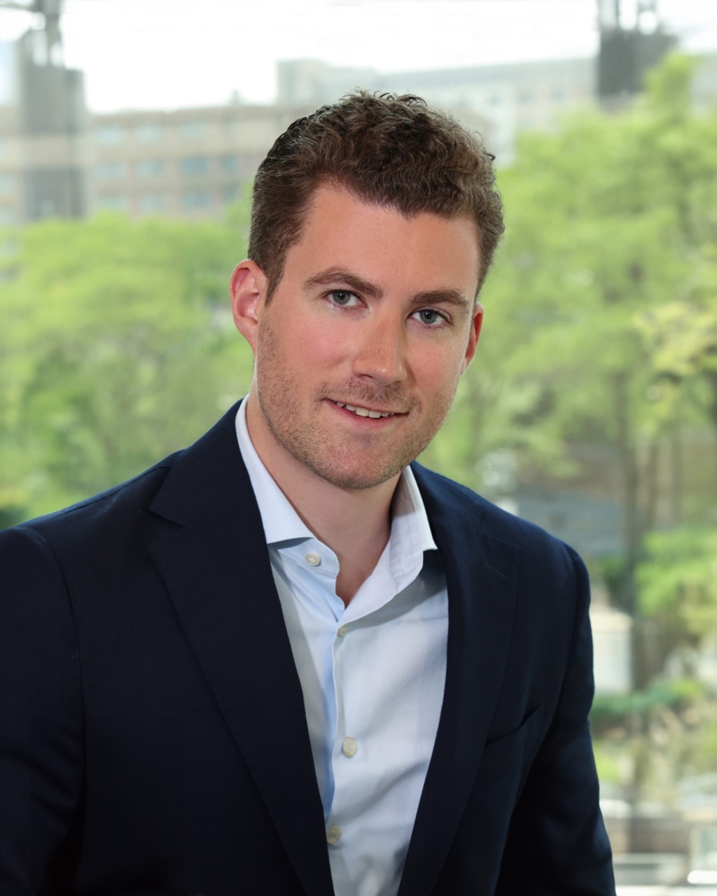 Brian McDonagh, Venture One executive, in a professional setting with greenery in the background