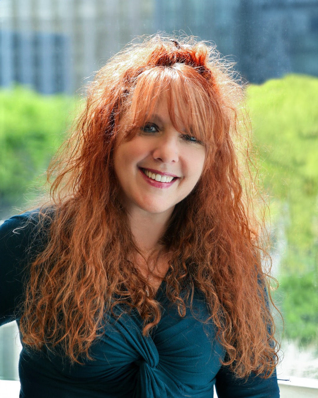 Michelle Roth with red hair smiling in modern office, representing Venture One leadership