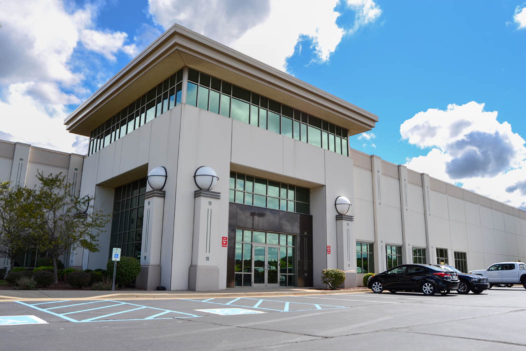 Modern industrial building at 6525 Daniel Burnham Dr featuring large windows and landscaped parking area