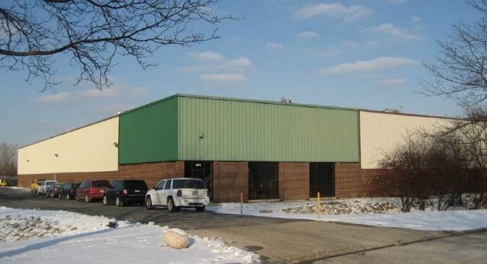 Glenview building with green-beige exterior and parking, Venture One