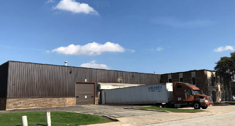 Industrial property featuring a loading dock and truck in front, acquired by Venture One.